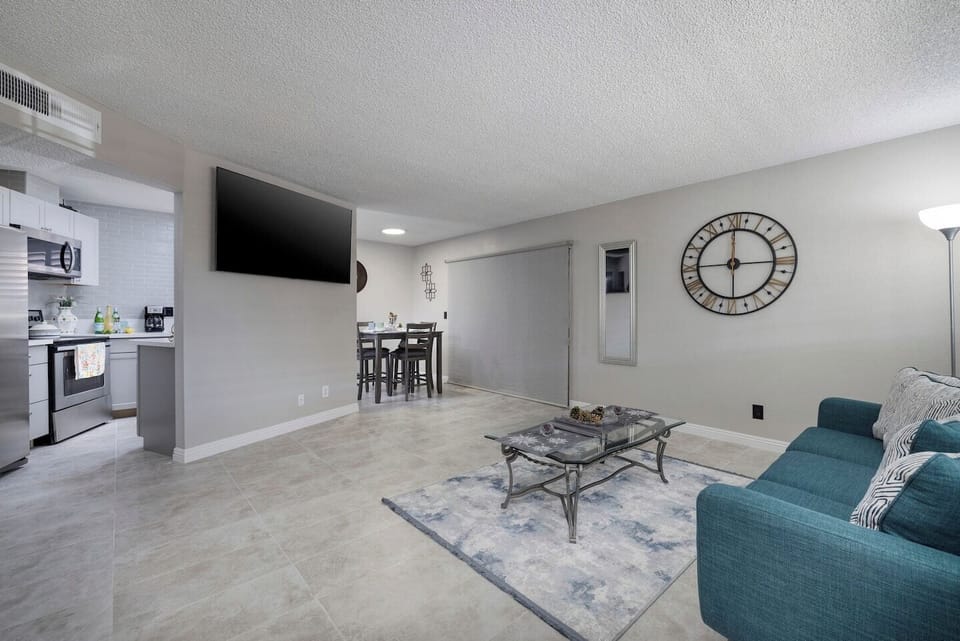 Family room with a large flat screen  mounted TV and a comfy couch to relax and enjoy a movie in between the hussle.  