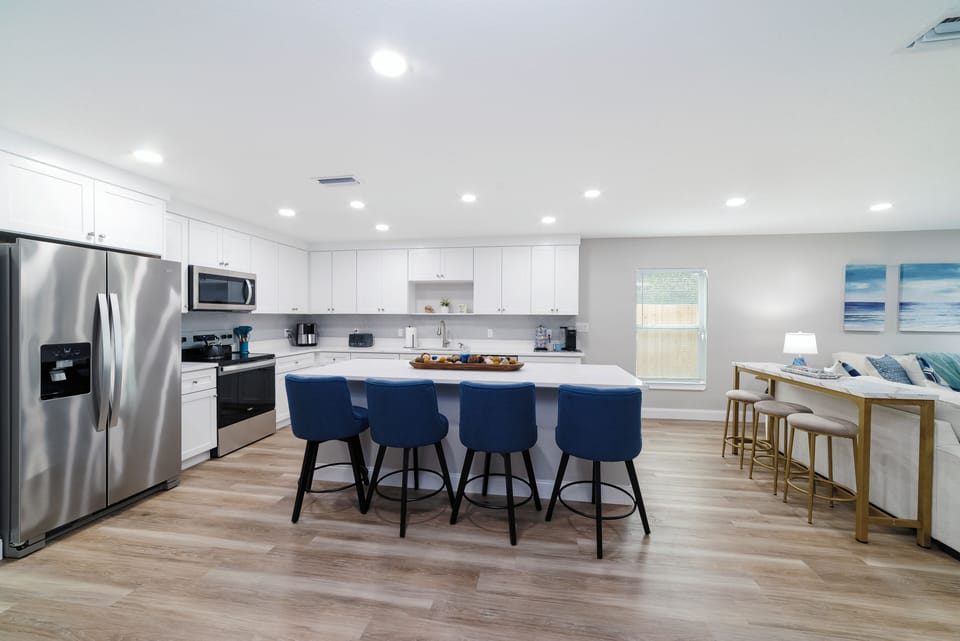 The kitchen is bright and open with 3 bar stools at the console table. 
