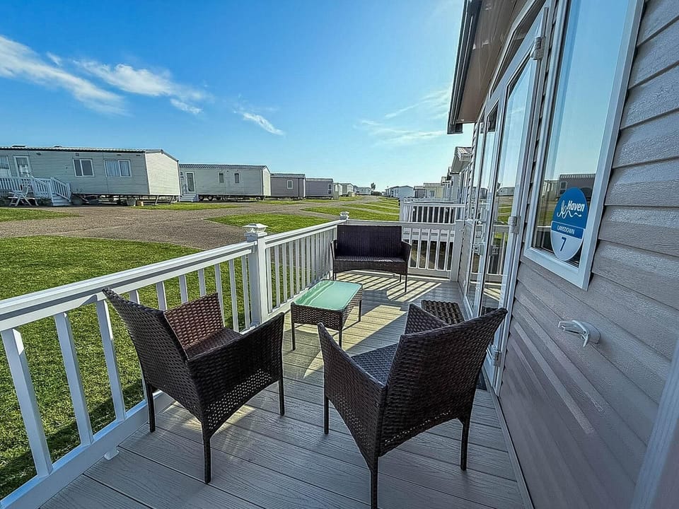 Unwind on the Norfolk coastline with a last-minute family holiday at Hopton Holiday Village, where a static caravan with decking offers the perfect spot to relax and enjoy the sea breeze.