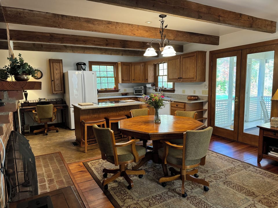 Full kitchen with eating area showing screened porch. 

