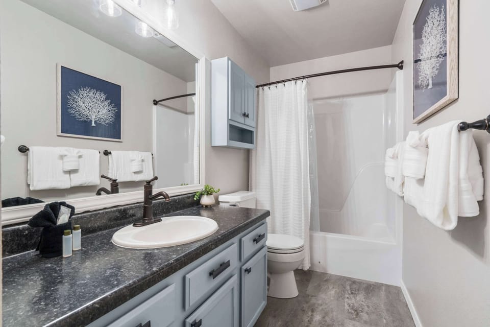 A single vanity & shower/tub combo await in the king ensuite