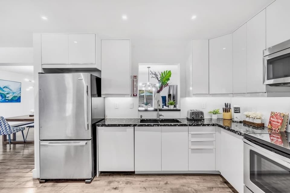 "Bright, modern, and pool-view perfect—this Airbnb kitchen and dining space blends style with comfort."