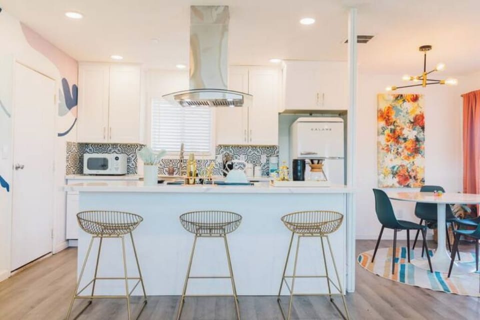Full kitchen adorned with retro inspired appliances and colors.