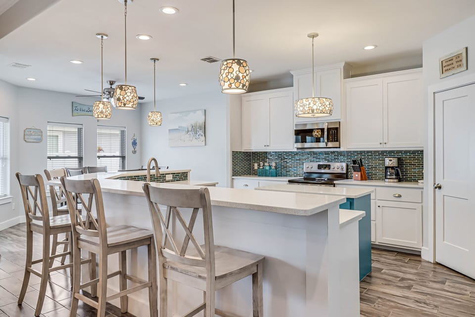 Your spacious kitchen invites culinary adventures with gleaming countertops, modern appliances, and elegant pendant lighting creating the perfect gathering spot.
