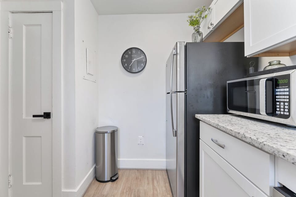 Modern kitchen with white cabinets, stainless steel appliances, and granite.