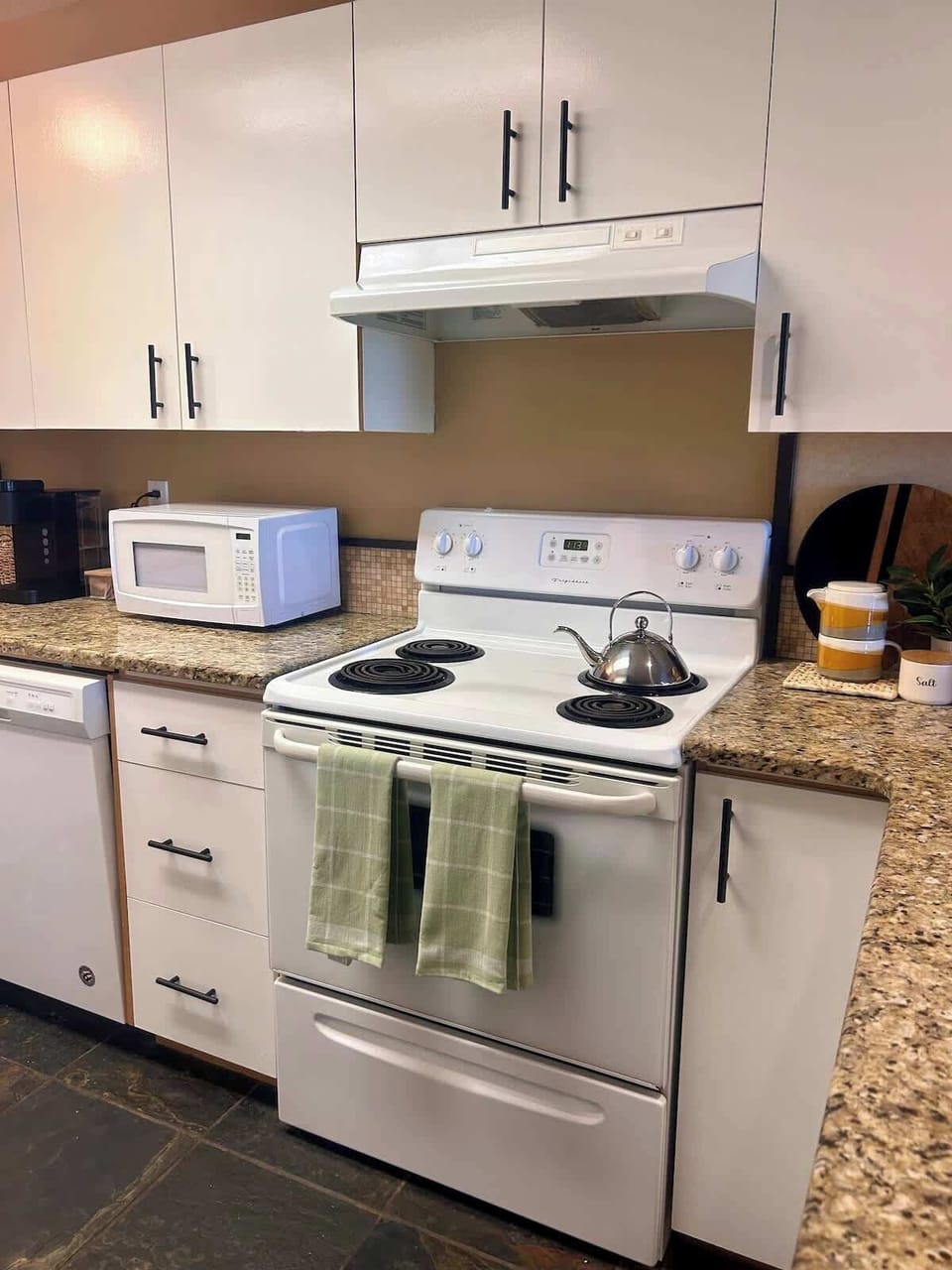Kitchen includes full fridge, stove, microwave and coffee machine.