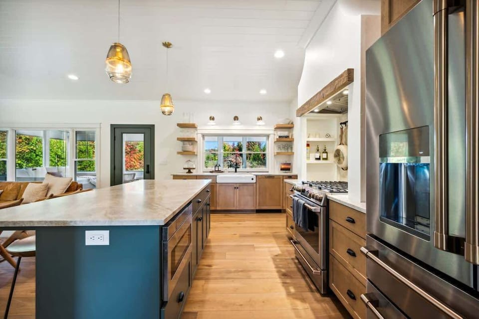 Step into the the gourmet kitchen, which is a chef’s dream, complete with high-end appliances and a fold-up window that opens into the large screened-in porch