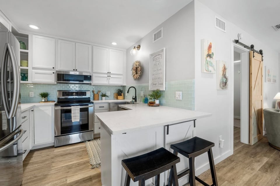 Custom kitchen with stainless steel appliances, quartz countertops and bar area 