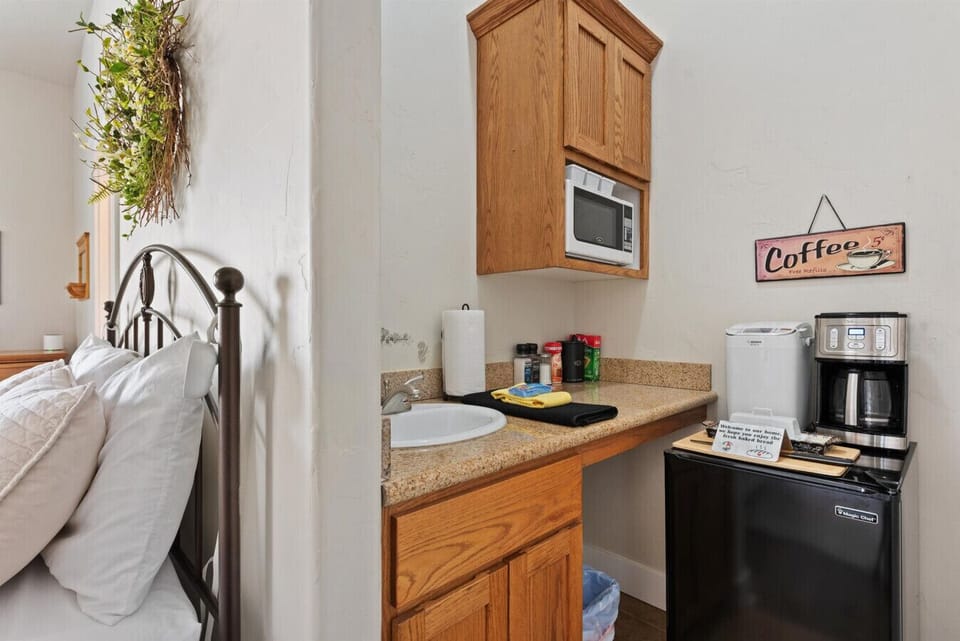 Small kitchenette (not a full kitchen) with a microwave, small sink, refrigerator, and coffee maker