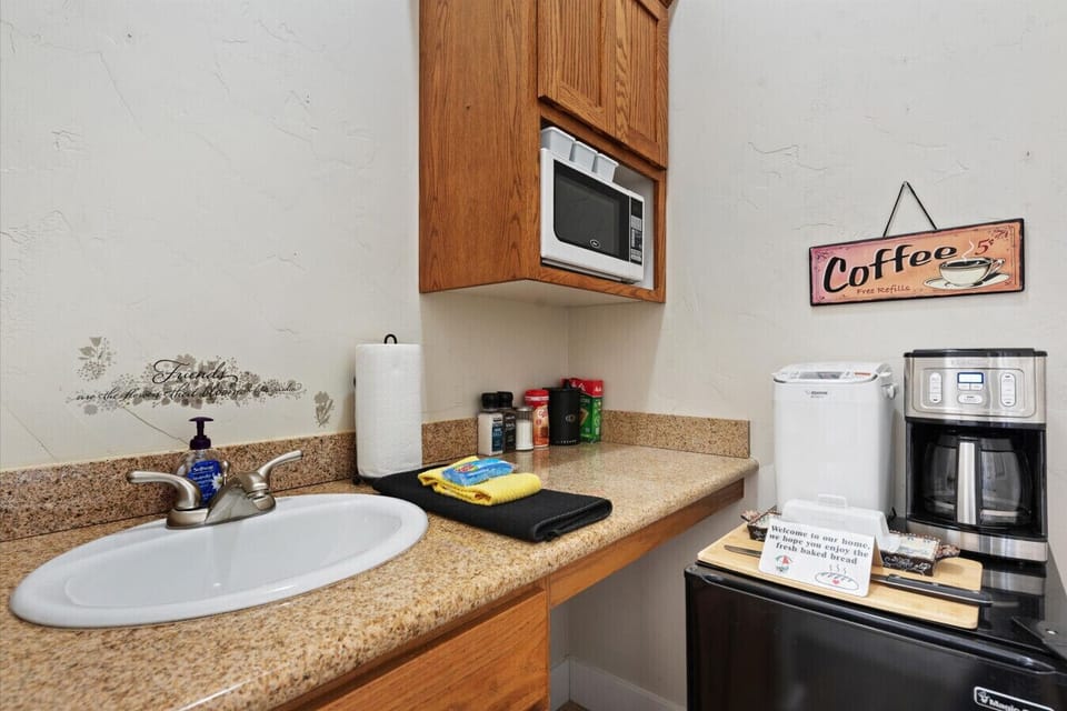 Small kitchenette (not a full kitchen) with a microwave, small sink, refrigerator, and coffee maker