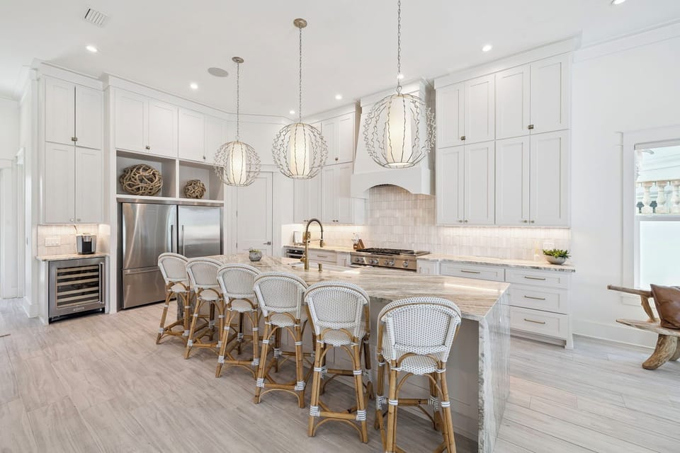 Your dream kitchen awaits with gleaming white cabinetry, stunning pendant lights, and a marble island perfect for morning coffee or evening gatherings.