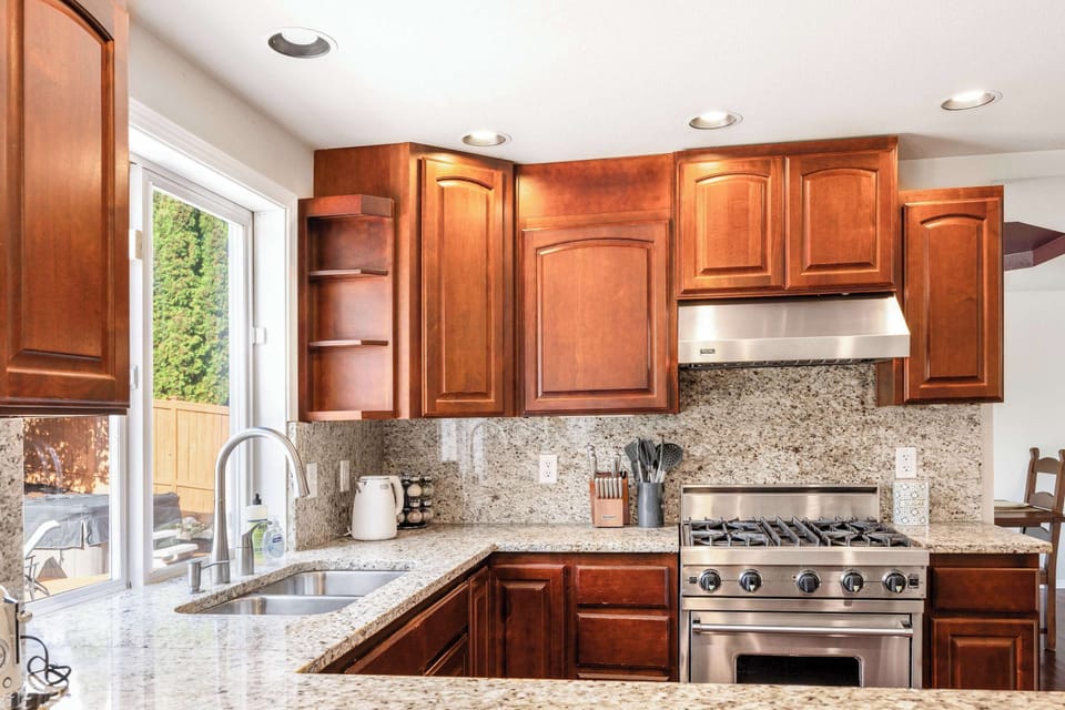 Our kitchen is fully stocked with a high-end gas range, granite countertops, and wooden cabinets. It’s designed for cooking enthusiasts, providing ample space to prepare meals in style.