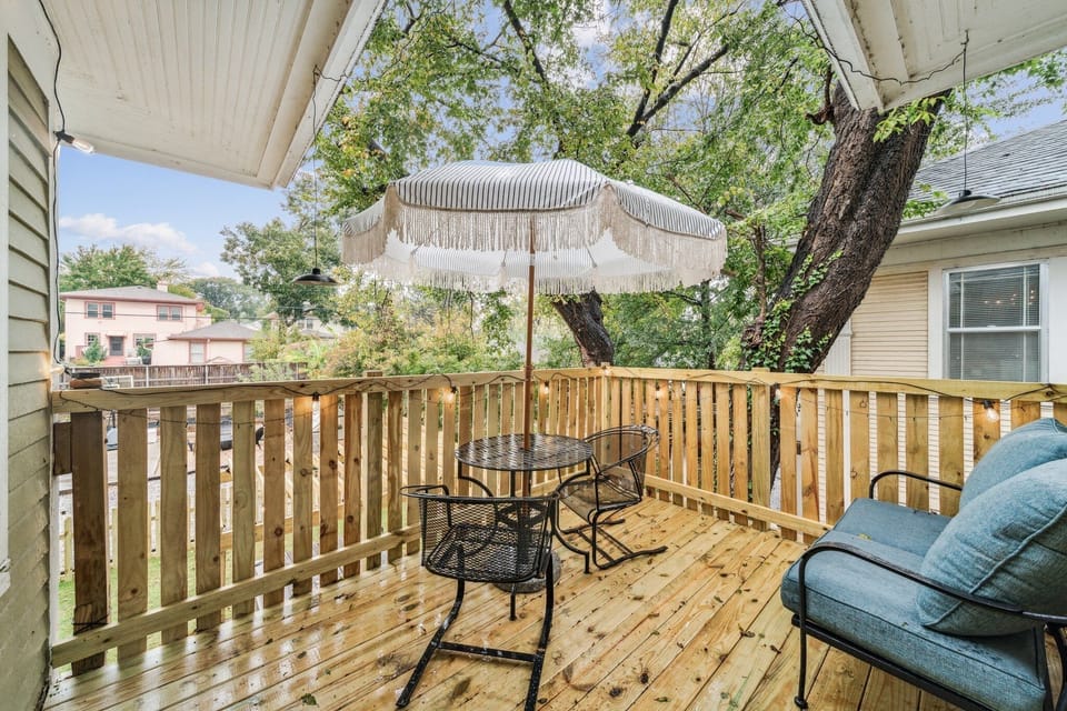 Private balcony with string lights, table, chairs and umbrella and cushioned couch is right off the 2nd Queen bedroom. 