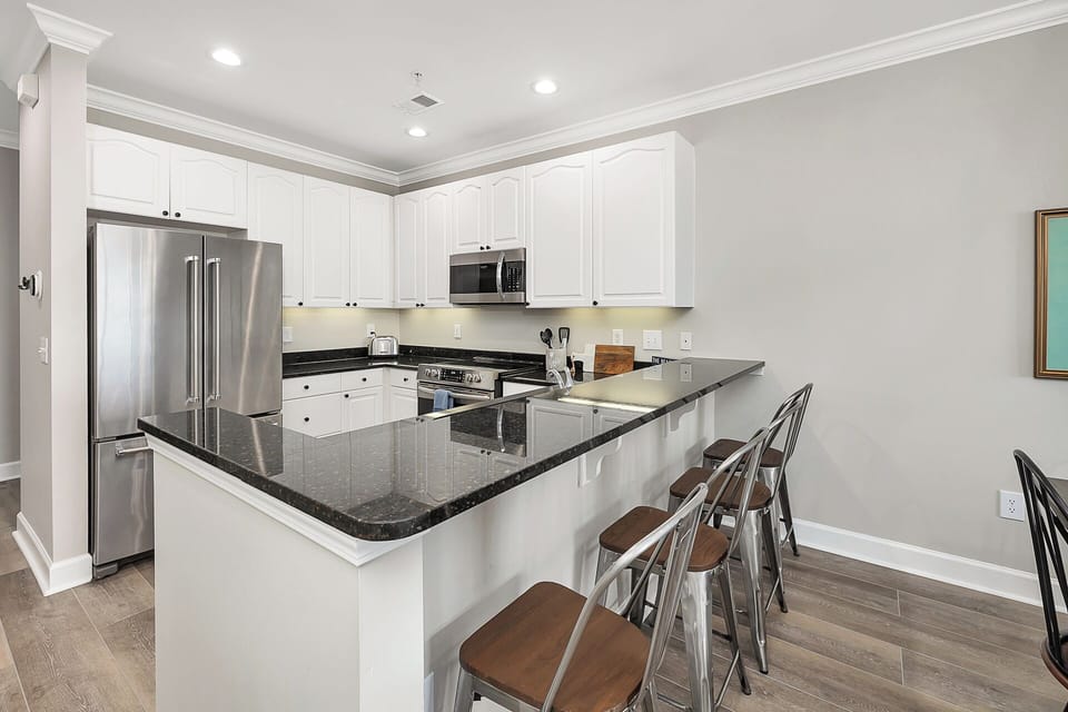 The kitchen is fully stocked and features a granite bar and 4 bar chairs. 