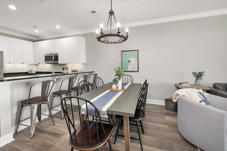 The spacious wooden dining table seats 6 people and is adjacent to the kitchen.