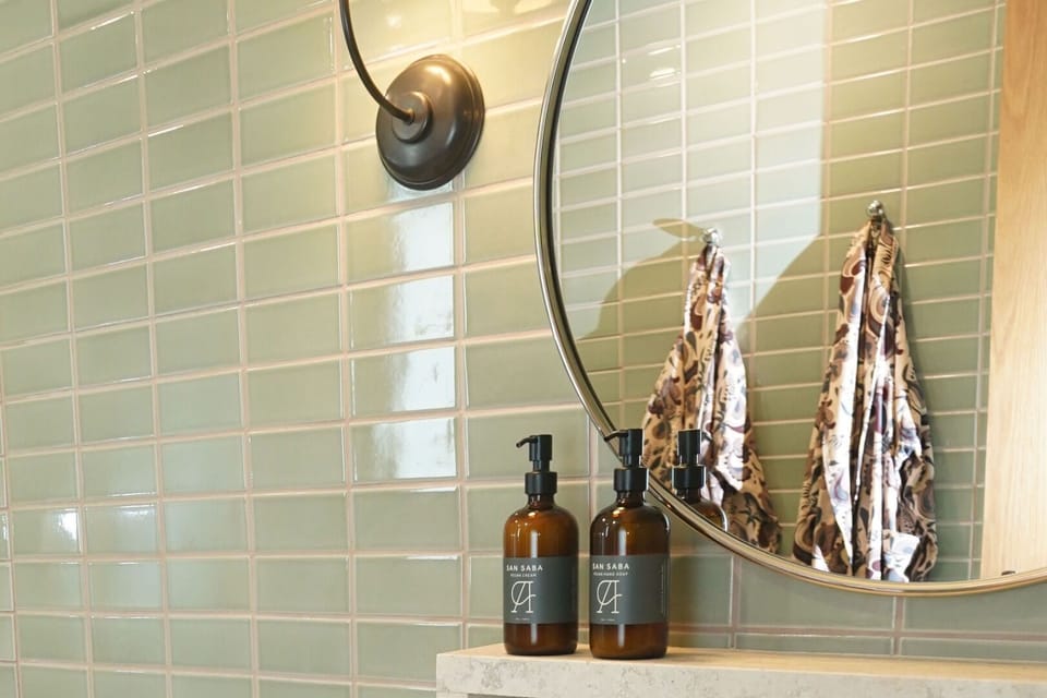 Refresh with spa-style soaps beneath glossy tile and warm light.