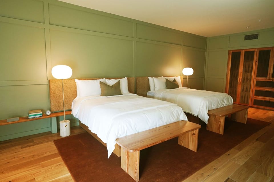 Settle into a spacious double-queen room with warm wood tones.