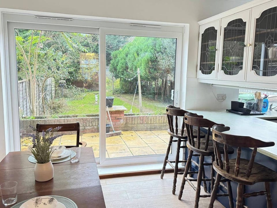 Breakfast table in bright kitchen with view of large garden.