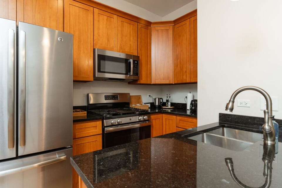 Channel your inner chef in this fully equipped kitchen, featuring stainless steel appliances, bar seating, and a dining table
