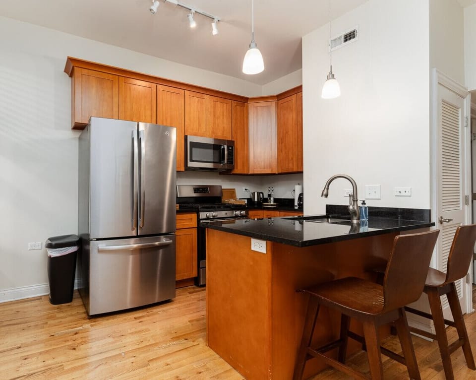 Channel your inner chef in this fully equipped kitchen, featuring stainless steel appliances, bar seating, and a dining table