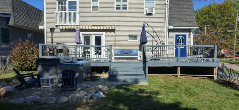 Backyard deck with grill, outdoor seating and hot tub