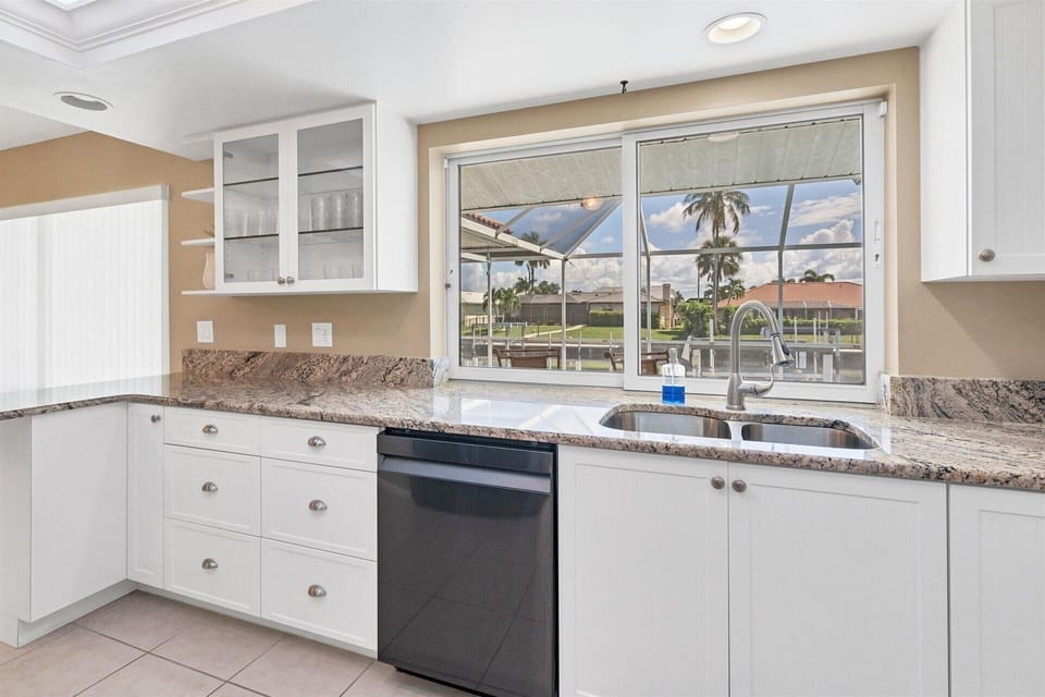 Fully-equipped kitchen with gorgeous view of pool and canal beyond