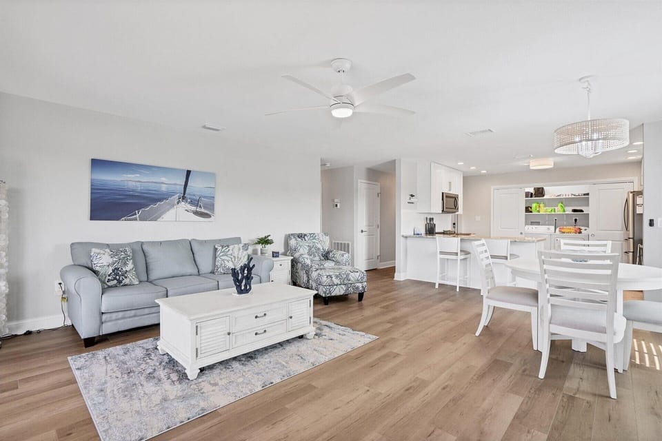 Beautiful, bright, open living space with pool view. Living room features comfy seating and 65-inch Roku TV. Dining table seats 4