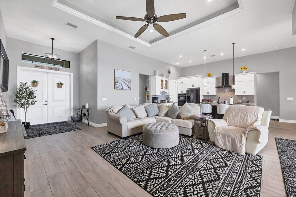 Large living room with view of the canal. Living room features comfy, ample seating and 85-inch Smart TV