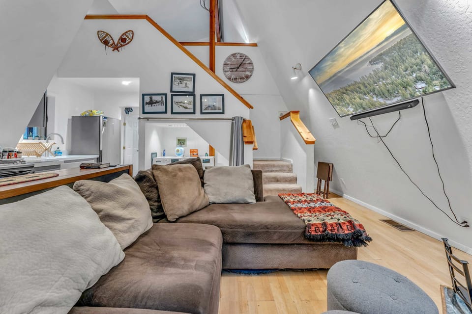 Living Room: Large sectional, wood-burning fireplace, 65” Smart TV
