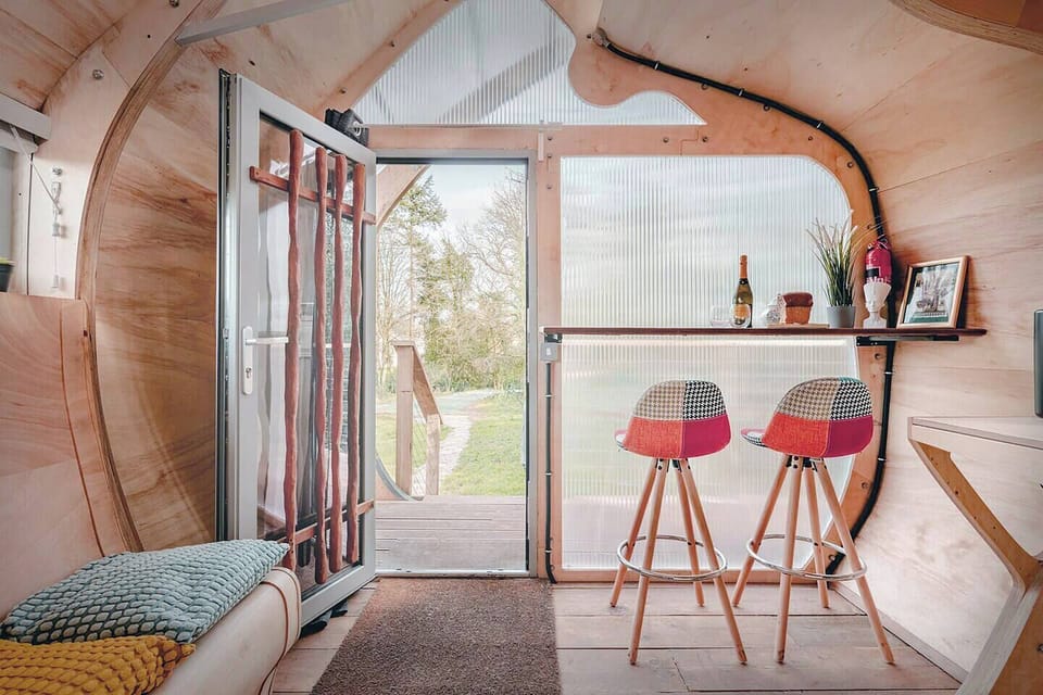 Bright Living Area Light-filled interior with colorful bar stools and cozy seating, opening to a view of the outdoors. (2)