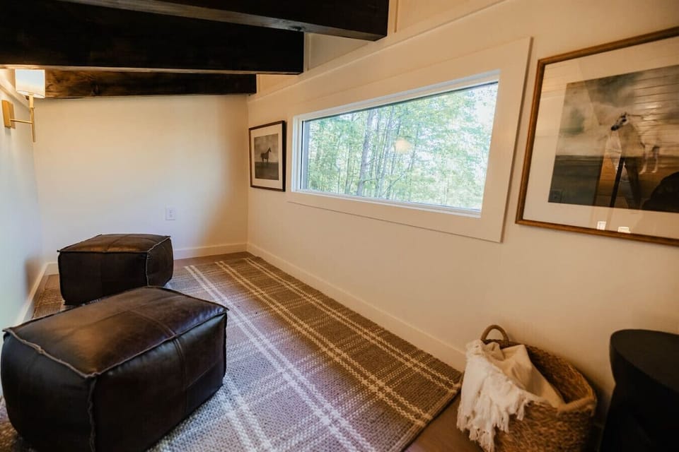 Quiet loft retreat featuring comfortable seating and peaceful woodland views