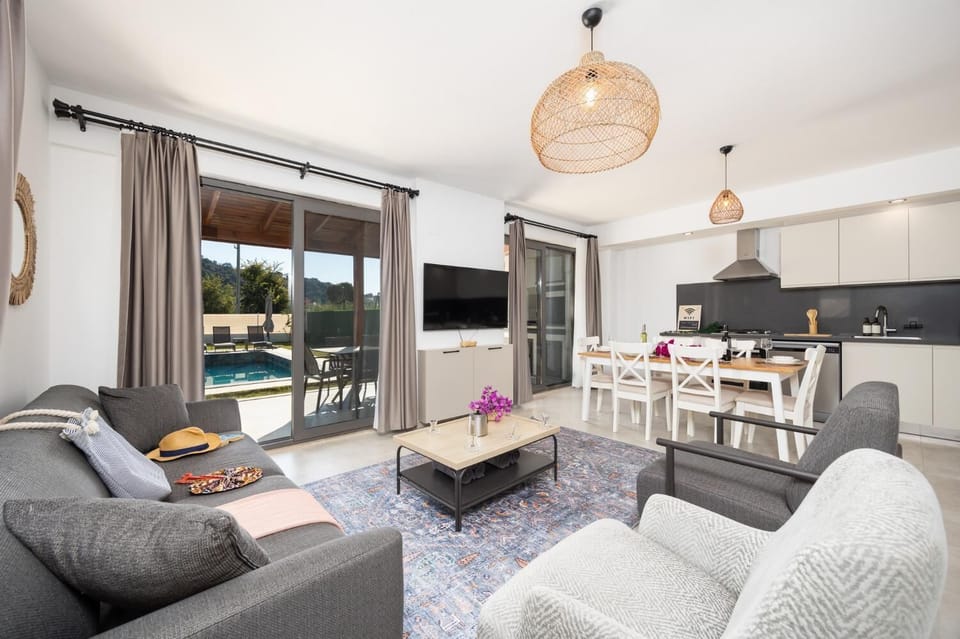 Open-plan living room with sofa, dining area, kitchen, A/C, WiFi internet, and satellite TV