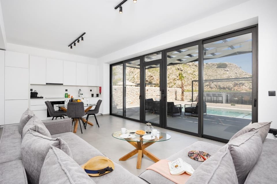 Open-plan living room with sofa, dining area, kitchen, A/C, WiFi internet, and satellite TV