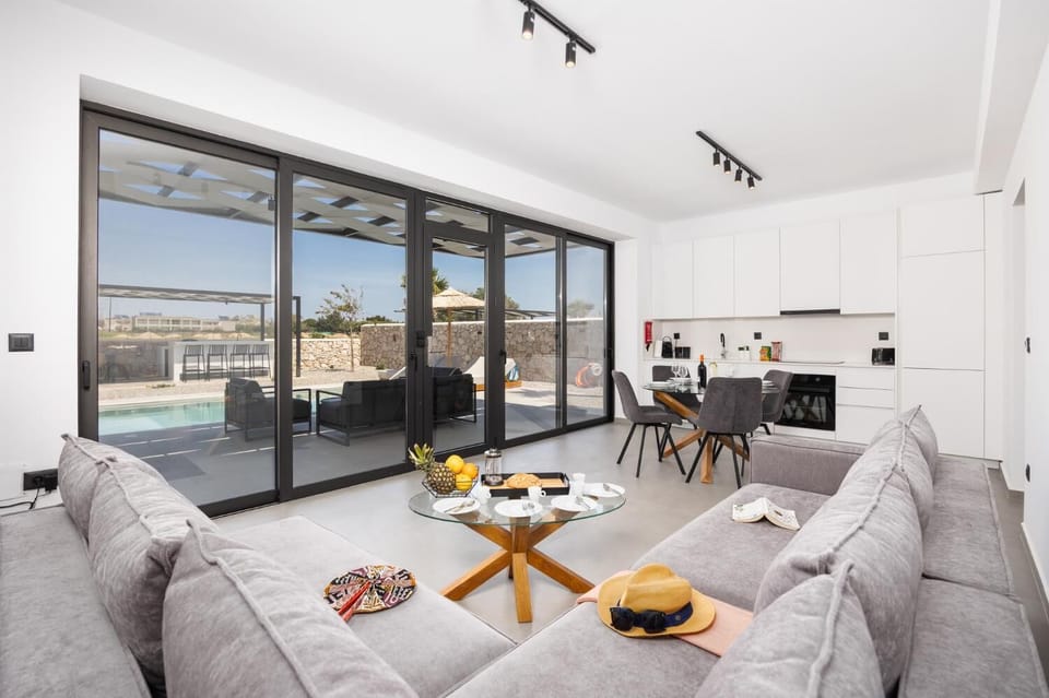 Open-plan living room with sofa, dining area, kitchen, A/C, WiFi internet, and satellite TV