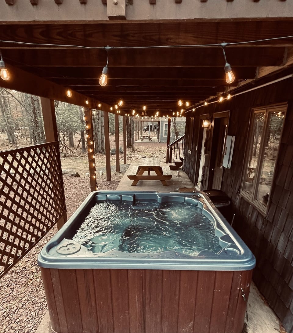 Hot Tub on the Ground Floor under the Deck and near the Picnic Table.   Gotta Love the Warmth.  Jump In! 
