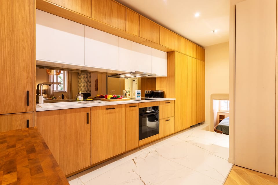 Modern and spacious kitchen, fully equipped (oven, coffee maker, ceramic hob) with wooden cabinets for a cozy atmosphere.