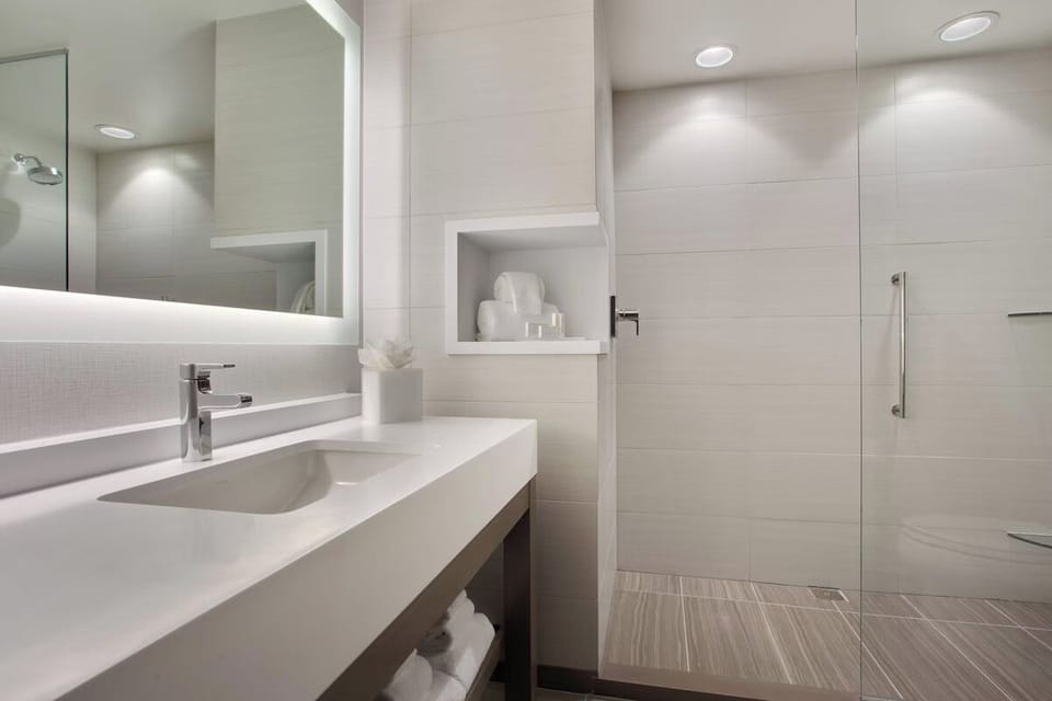 Indulge in a warm shower beneath soft lighting and sleek tile.