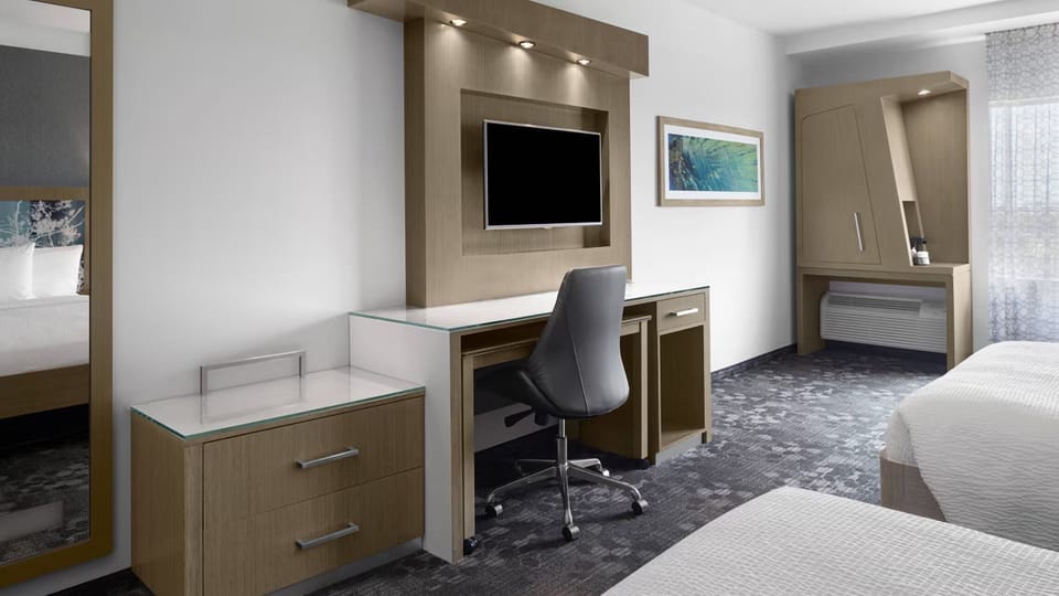 Settle in with spacious desk, large TV, and sleek storage.