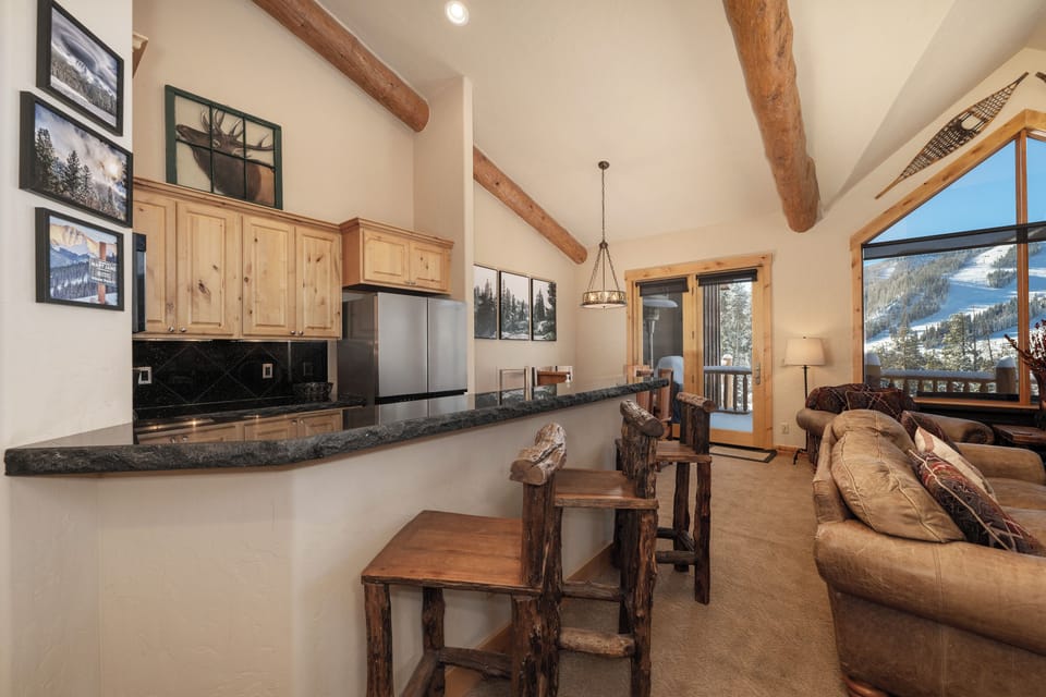 - Open concept kitchen and bar seating with rustic wood style   - Perfect for family meals and après ski gatherings indoors   - Mountain lodge charm with functional kitchen and bar stools