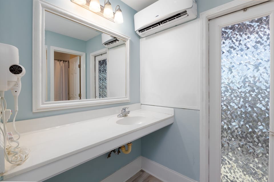 Clean vanity area with sink and hair dryer