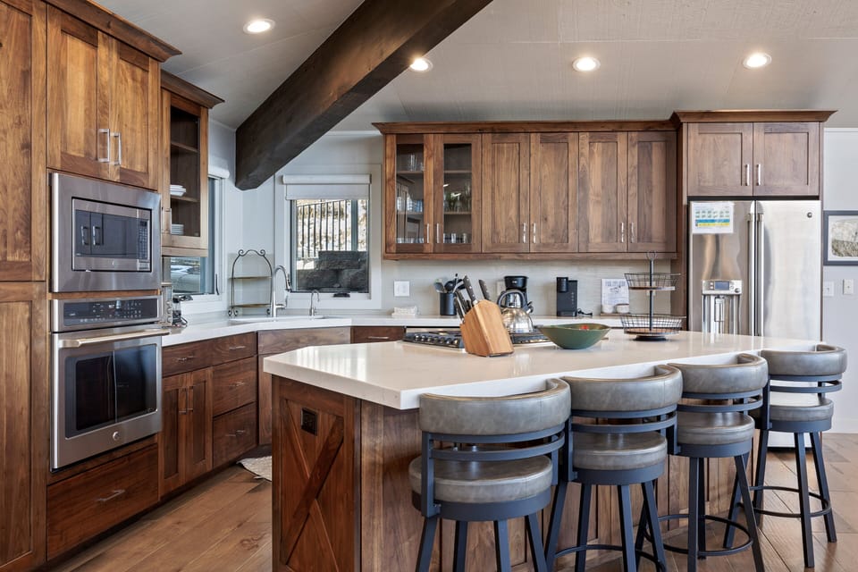 - Spacious kitchen island with seating for group meals and social time  
- Modern appliances and rustic wood accents create mountain style  
- Open concept connects kitchen with dining and entertainment areas