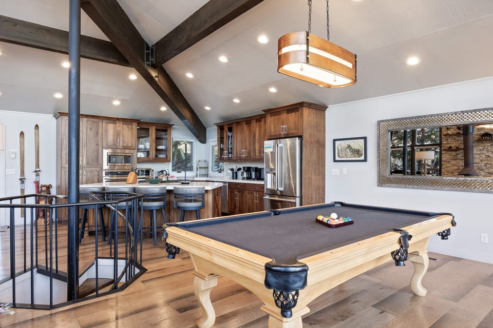 - Open layout with pool table perfect for family fun and group activities  
- Modern kitchen with wood cabinetry and stainless appliances included  
- Comfortable bar seating connects dining and entertainment spaces