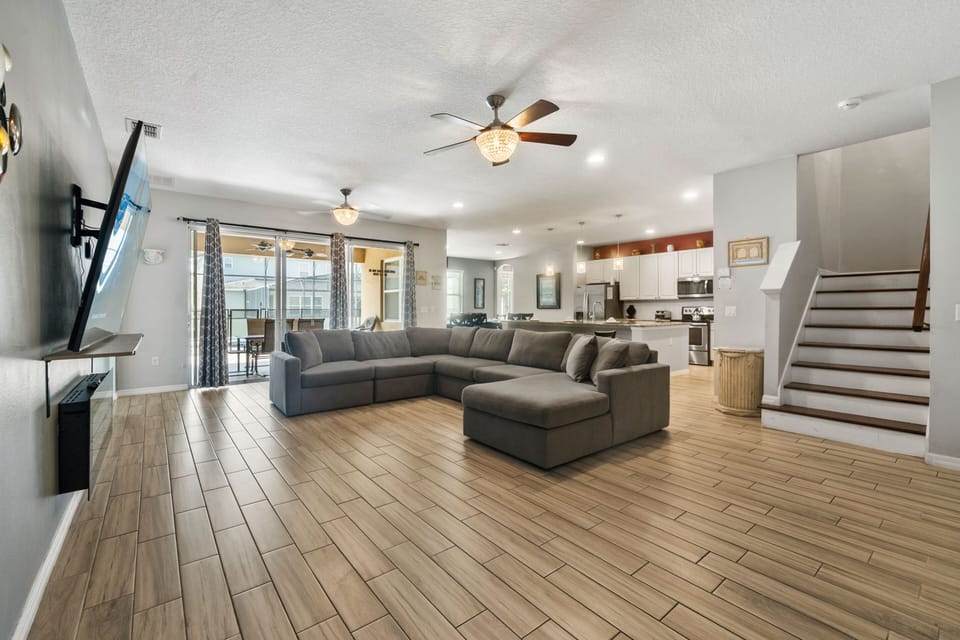 - Spacious open-plan living with modern sectional sofa  
- Smart TV entertainment and sliding doors to pool  
- Ceiling fans and bright natural light create comfort