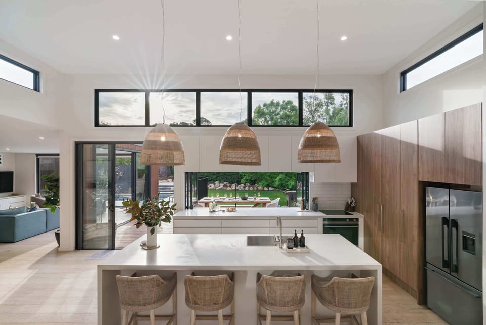 Large kitchen, island bench looking out upon the decking and backyard.