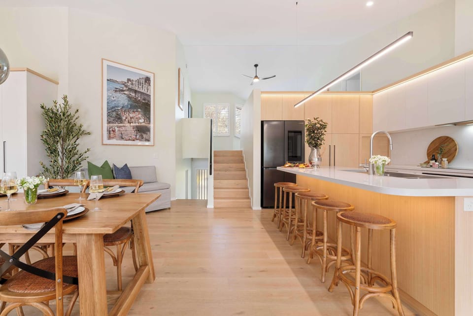 Open plan dining and kitchen spaces, with the master bedroom and ensuite upstairs, an additional main bathroom, Queen bedroom and Queen sofa bed area.