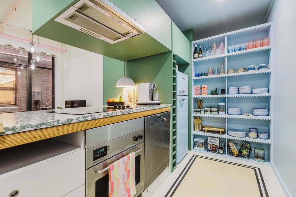 KITCHEN: A fully equipped loft-style kitchen with bold cabinetry and premium appliances—designed to inspire your culinary creativity.