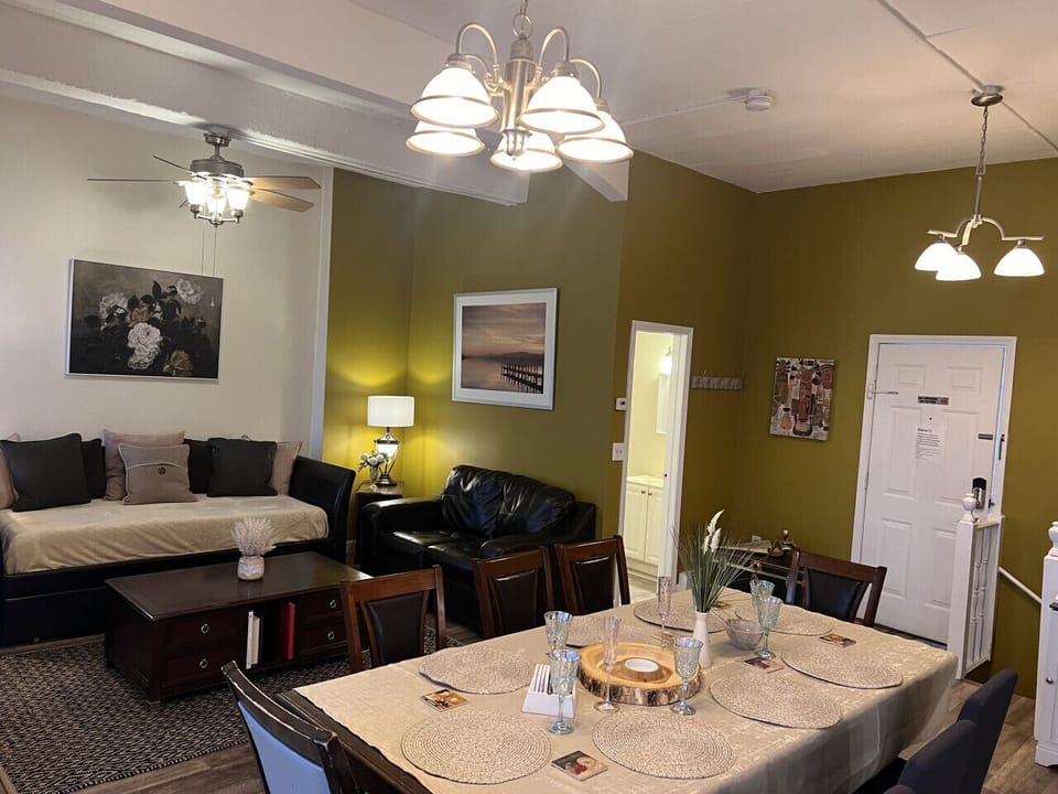 Living room, apartment # 4 , ( 1 Queen size pullout Sofa) , ceiling, fan, TV, dining area, AC on window.