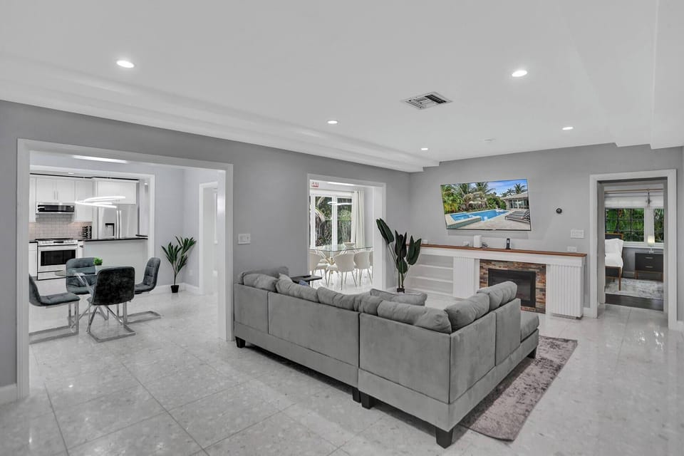 Living Area: Open-Concept Living Area with Seamless Flow to Kitchen and Poolside Views