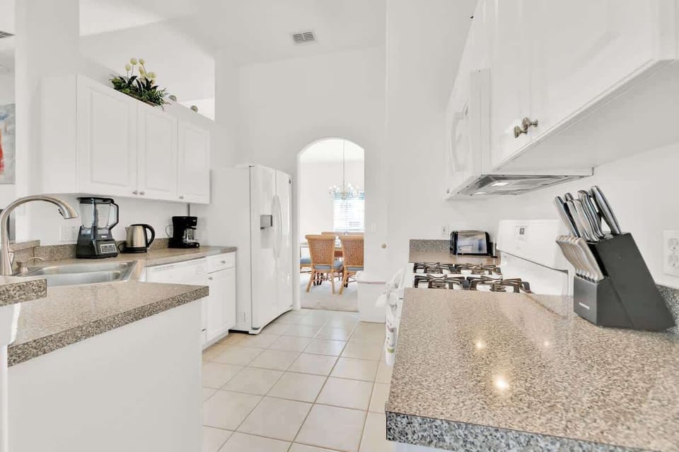 With towering ceilings and top-notch essentials like a knife set, cutting board, Ninja blender, and a fridge with a water and ice dispenser, this kitchen is a superb space for all your culinary needs.