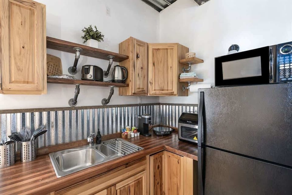 Kitchenette area with Single induction cook top, toaster, refrigerator, kettle and microwave.